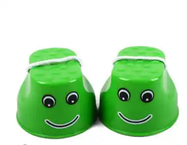 Green children's outdoor stilts with cheerful face design and rope handles, ideal for enhancing motor skills through outdoor play.