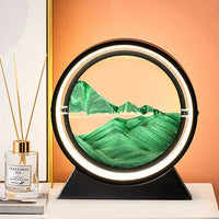 Moving Sand Art Picture Frame showcasing blue sand forming serene landscapes in a circular frame with a white base, set against a green background.