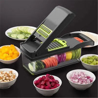 Black multifunctional kitchen slicer with a transparent container, surrounded by bowls of diced and sliced vegetables.