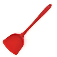 Red silicone spatula with a long handle, designed for flipping and serving food with ease in the kitchen.