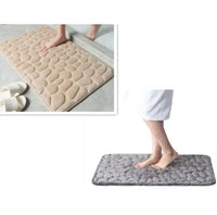 Set of beige and gray super absorbent shower room floor mats with pebble-like textures, shown in bathroom settings.