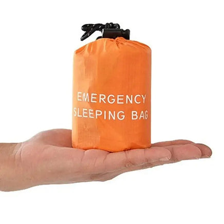 Compact orange waterproof reusable emergency sleeping bag displayed on a hand, highlighting its lightweight and portable design.