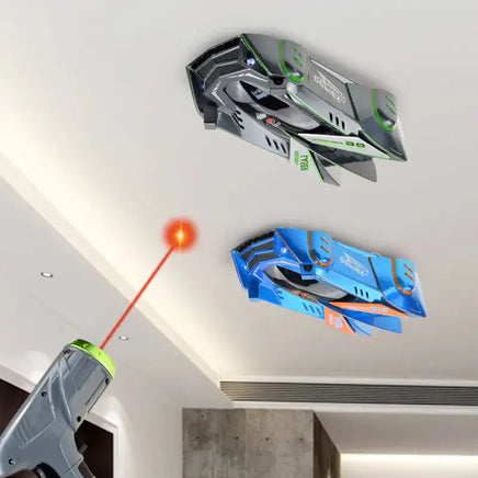 Green and blue anti gravity car toys defying gravity on a ceiling, controlled by a laser-guided remote.