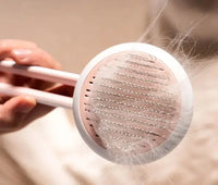 Close-up of pink Automatic Hair Remover & Massage Comb removing pet hair, showcasing its effective grooming bristles.