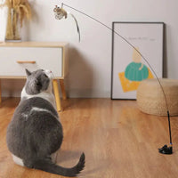 Gray and white cat observing a bird-shaped toy attached to a fishing rod-style stick, ideal for cat playtime.