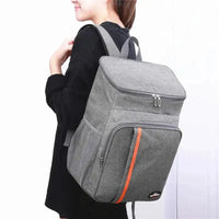 Person carrying a gray portable thermal lunch bag with padded straps, ideal for keeping meals fresh and easy to transport.