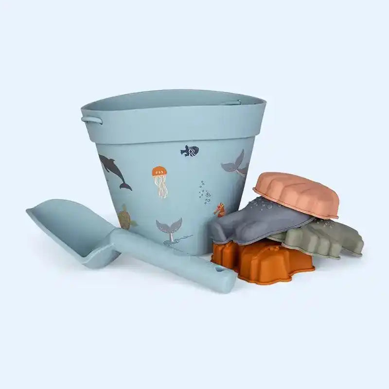 Ocean-themed beach toy set with a blue bucket decorated with sea creatures, a matching shovel, and marine animal sand molds for seaside adventures.